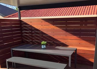 Covered timber deck with slatted privacy screen, outdoor table and bench