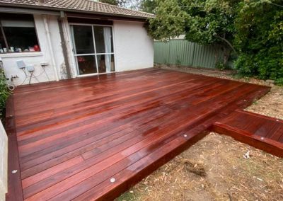 Freshly oiled timber deck in a backyard beside a house