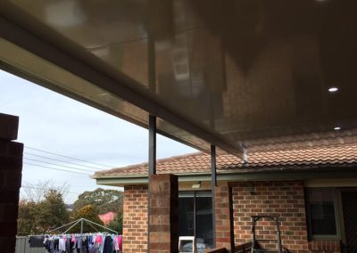 Covered pergola roof with downlights over a deck with timber balustrade