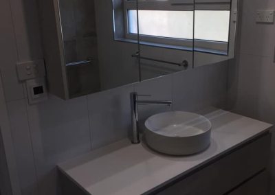 Grey wall-hung vanity with round vessel basin and mirror cabinet