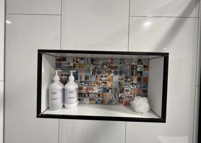 Recessed shower niche with colourful patterned tile backing