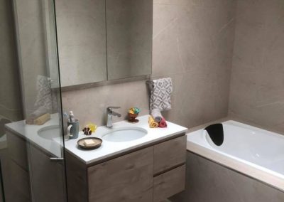 Bathroom with built-in bath, timber-look vanity with white basin and mirror cabinet