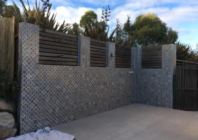 Courtyard walls clad in patterned tiles with timber slat panels above