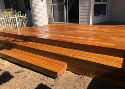 Large timber deck with wide steps along the back of a house