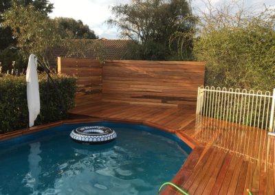 Timber deck and slatted screen around an above-ground pool