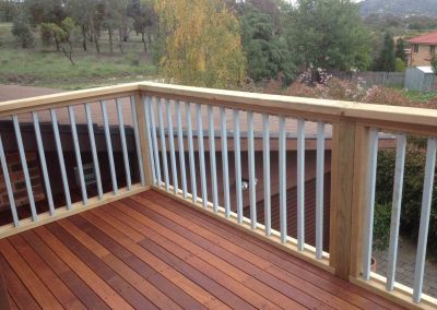 Timber deck with a timber and white balustrade overlooking a paddock