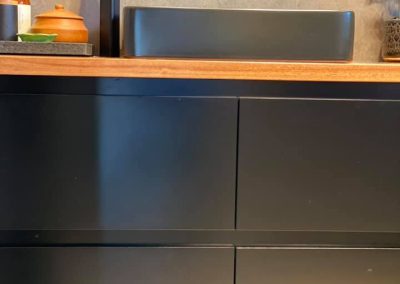 Black vanity with timber top, dark vessel basin and tall black mixer
