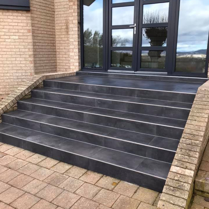 Tiled front steps leading up to glass entry doors