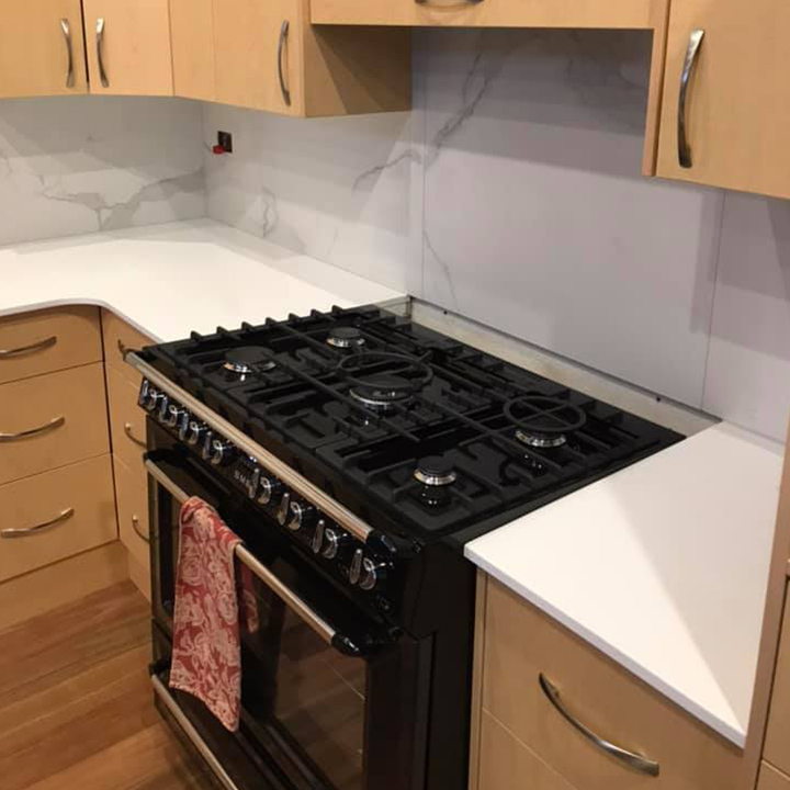 Kitchen with a black freestanding gas cooker and white stone benchtops