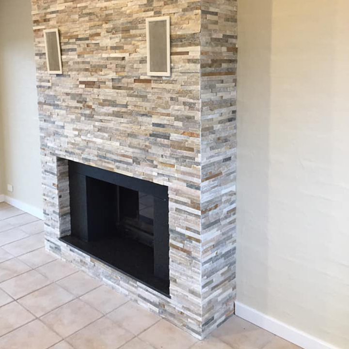 Fireplace surround clad in stacked stone, with tiled floor