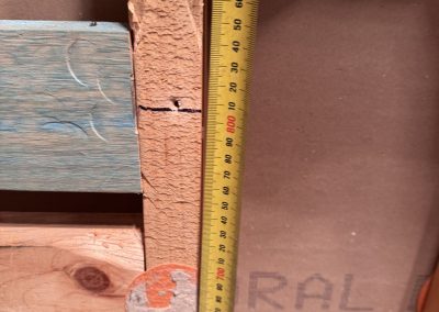 Tape measure held against timber wall framing