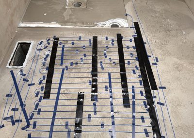 Underfloor heating cables taped across the bathroom floor before tiling