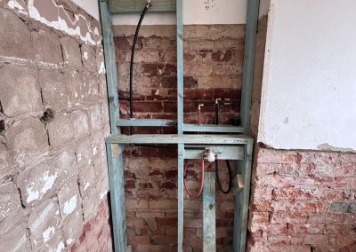 Bathroom stripped to the brickwork with a new in-wall frame for the toilet