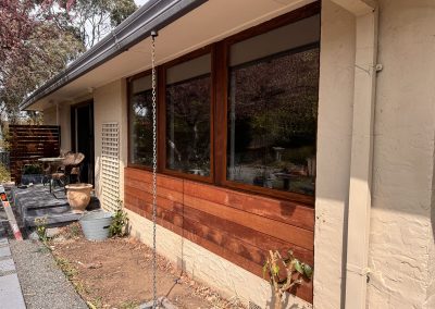 Side view of timber cladding below large timber-framed windows
